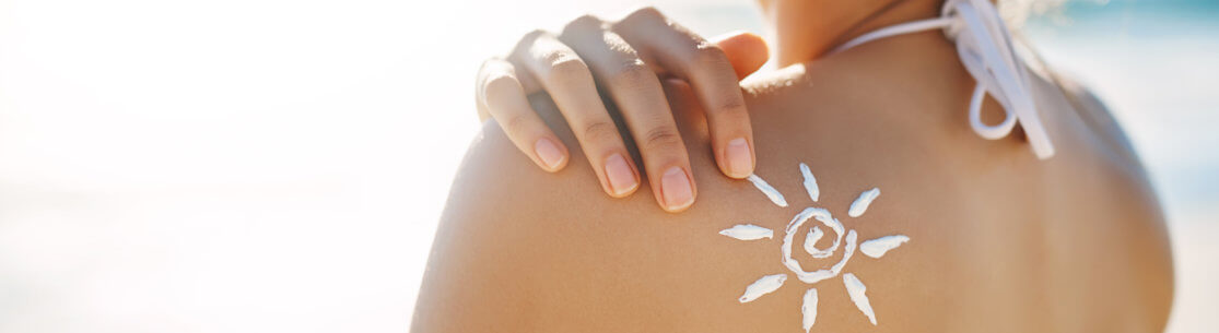 Cropped shot of a young woman posing with suntan lotion on her shoulder