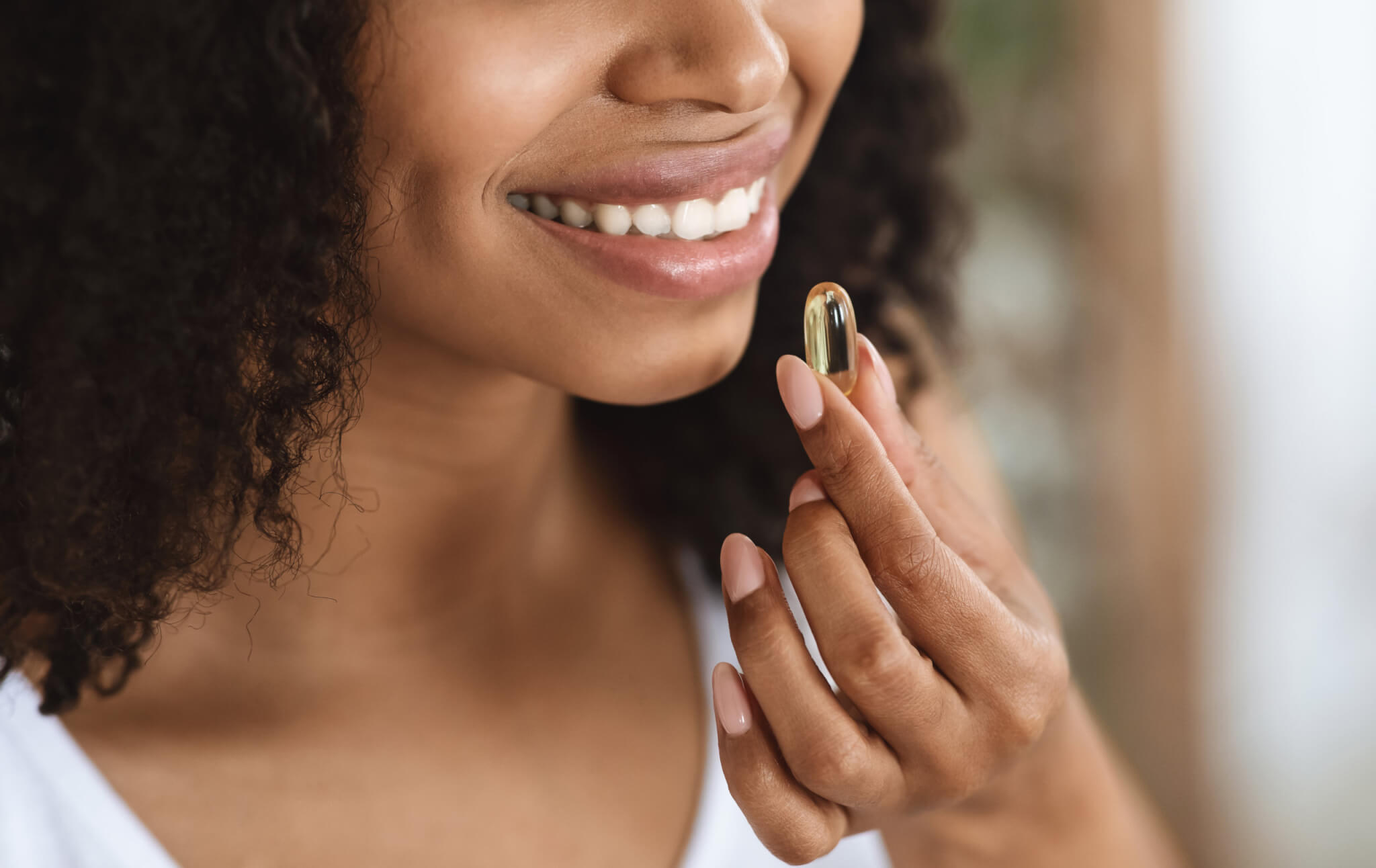 Beauty Supplement. Closeup Of Smiling Black Woman Taking Vitamin Pill Capsule, Having Diet Nutrition, Cropped Image