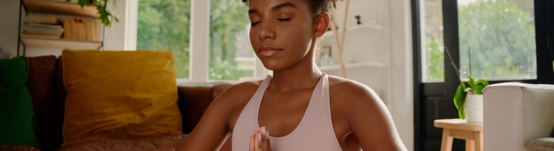 Woman with closed eyes practicing yoga with joint hands